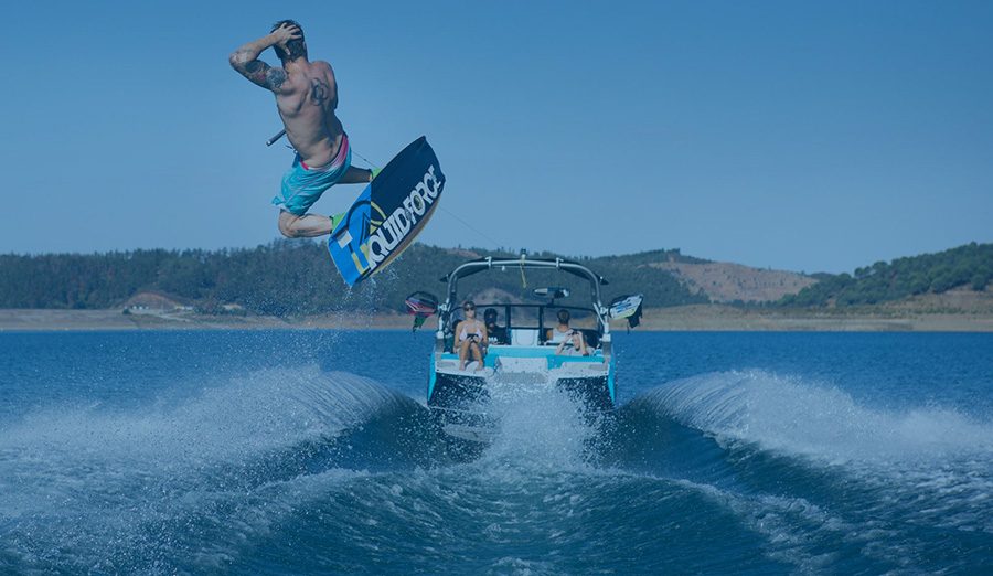 Teknenin arkasında atlayış yapan wakeboard sporcusu